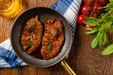 Saltimbocca. Veal schnitzel with sage and Parma ham. Italian specialty. Top view.