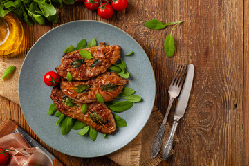 Saltimbocca. Veal schnitzel with sage and Parma ham. Italian specialty. Top view.