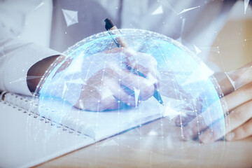 Double exposure of Man writing in notepad with business icons on background.