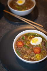 Spicy japan  soup Bifu Suimono on black plate. Close up. Side view.