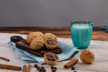 Obraz na płótnie Canvas chocolate chip cookies and glass of milk in background. baking nuts with chocolate and cinnamon