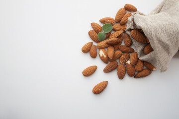 Almond pouring out from the sackcloth bag. White background
