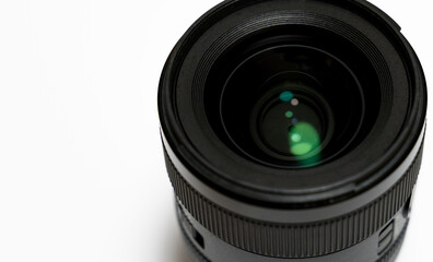 Close-up of digital camera lens on white background.