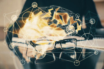 Double exposure of writing hand on background with brain hologram. Concept of learning.
