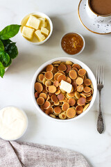 Mini pancake cereal with butter on white background. Cup coffe, sour cream and jam. Trendy Food breakfast Concept.