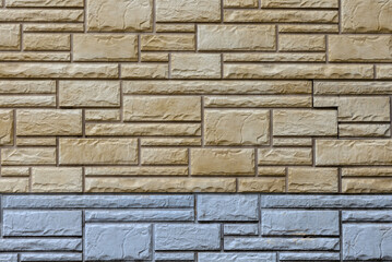 Wall with decorative tiles in the form of beige and blue brickwork