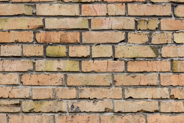 A wall of very old brick red-orange and brown with destruction. Texture