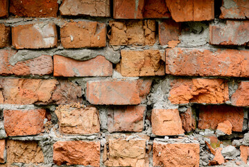A wall of very old brick red-orange and brown with destruction. Texture