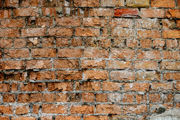 A wall of very old brick red-orange and brown with destruction. Texture