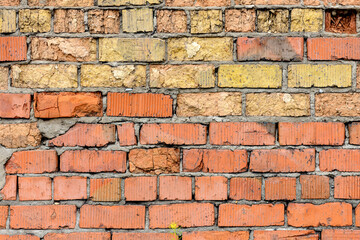 Fototapeta premium A wall of very old brick red-orange and brown with destruction. Texture