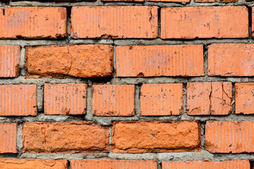 Obraz premium A wall of very old brick red-orange and brown with destruction. Texture