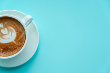 Hot coffee with late art on blue background