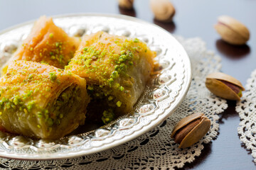 Baklava with walnut and pistachio. Turkish dessert baklava with pistachio and traditional silver serving set. Festival of sacrifices. Ramadan holiday. 