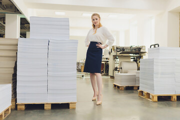Young woman working in printing factory. Printing Press.