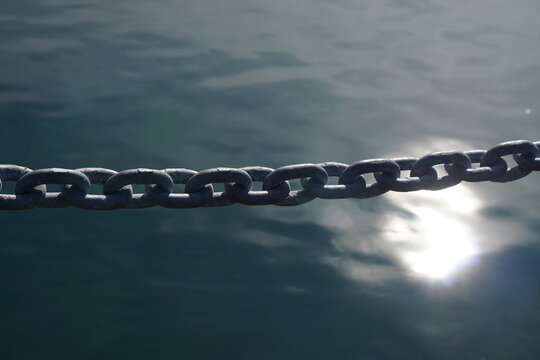 The metal chain on the water surface and sunlight reflection background.