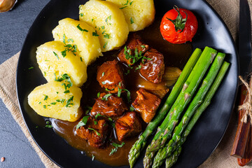dumplings with beef goulash and green asparagus