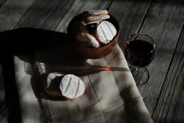 Closeup shot of baked cookies and  wine in a glass on a wooden surface © Fotoe Commerce/Wirestock