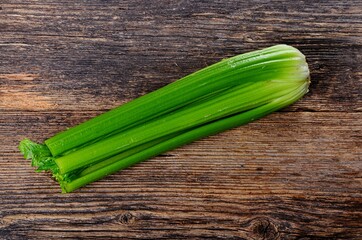Bunch of fresh celery stalk with leaves on old wooden background