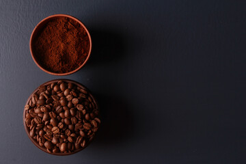 Roasted and ground coffee beans in round bowls on dark blue table background. Close-up, top view, copy space. Coffee shop, morning, barista workplace concept