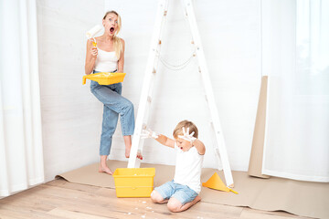 Mother with son painting the wall in home.