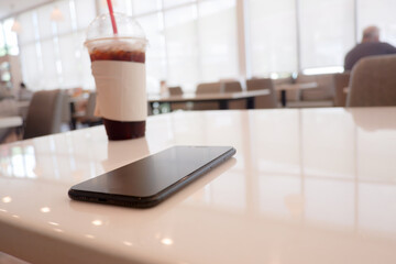 cropped shot view of smart phone on the table at coffee shop.