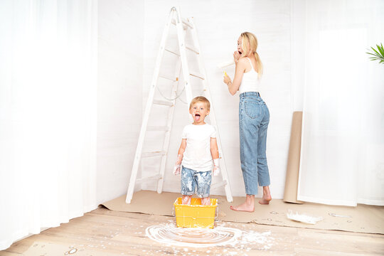 Mother with son painting the wall in home.