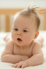 Newborn 4 month old baby on tummy. Parenting, childhood, education concept. Skin care, health care.