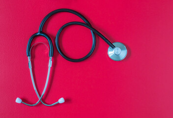 Medical stethoscope on red color background