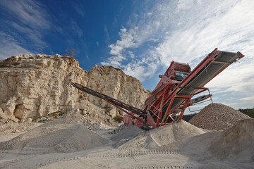 special equipment in a sandy quarry against a blue sky