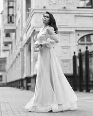 Obraz premium Young beautiful woman wearing long pink dress. Outdoor fashion full length portrait.