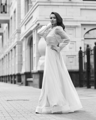 Young beautiful woman wearing long pink dress. Outdoor fashion full length portrait.