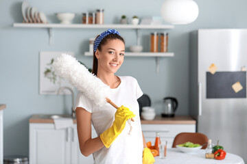 Beautiful young woman cleaning kitchen