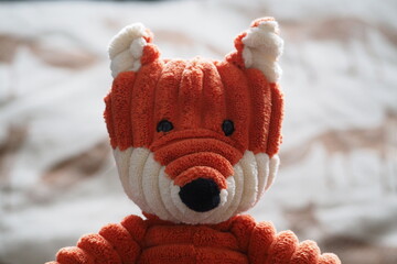 Głowa zabawki rudy lis na rozmytym tle