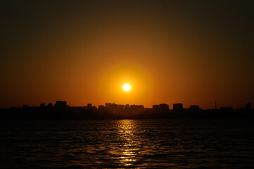 Fototapeta premium Sunset over the city, view from the river