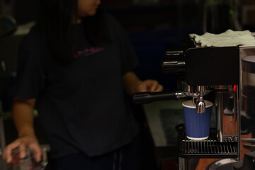 Paper cup of fresh coffee and coffee maker machine in street food at Pilok, Kanchanaburi, Thailand.