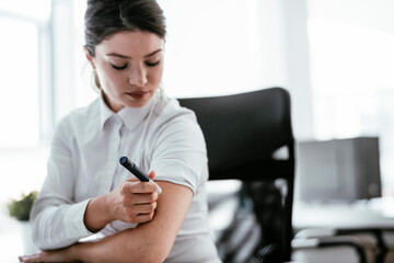 Businesswoman giving herself an injection of insulin.	
