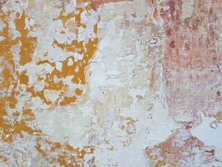 Damaged wall texture. Yellow and red paint peeling off the wall.