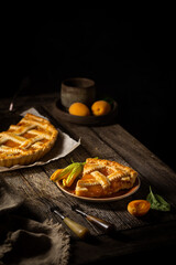 Summer homemade apricot or peach pie on dark wooden background. Delicious fruit dessert. Fruit cake.
