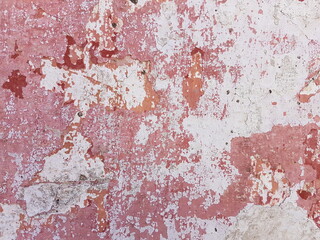 Damaged wall texture. Pale red paint peeling off the wall.