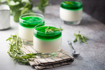 Dessert Panna Cotta with green tarragon sauce and fresh tarragon on white background