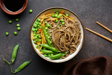 Buckwheat noodles with peas, carrots, onions and soy sauce. Vegan soba noodles. Asian food