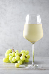 Misted glass of cold white wine on gray background