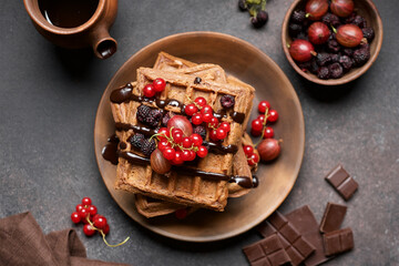 Chocolate Belgian waffles with berries. Sweet breakfast. Baking brown background