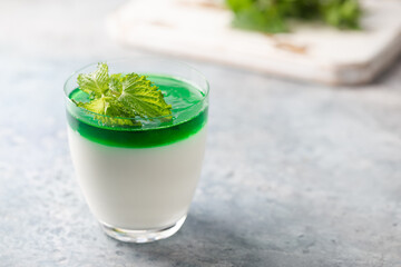 Dessert Panna Cotta with mint sauce and fresh mint on white background