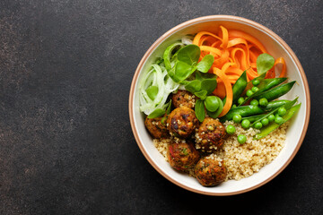 Vegan Buddha bowl with vegetable balls, quinoa, carrots, cucumber and peas. Vegetarian healthy balance nutrition