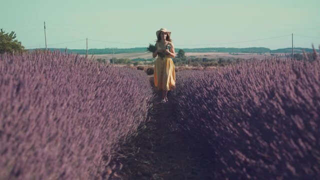 Girl walking accross a lavender field in summer