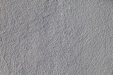 Grainy texture of off-white plastered wall.
