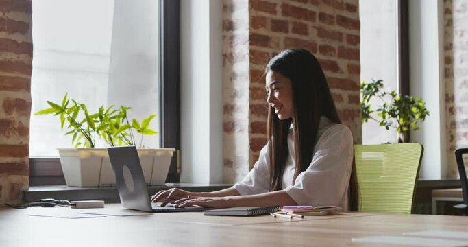 Positive asian student girl greeting teacher via video chat