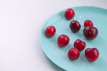 Naklejka na ściany i meble ripe cherries on a blue plate