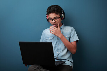 Excited boy wearing headset learning through laptop